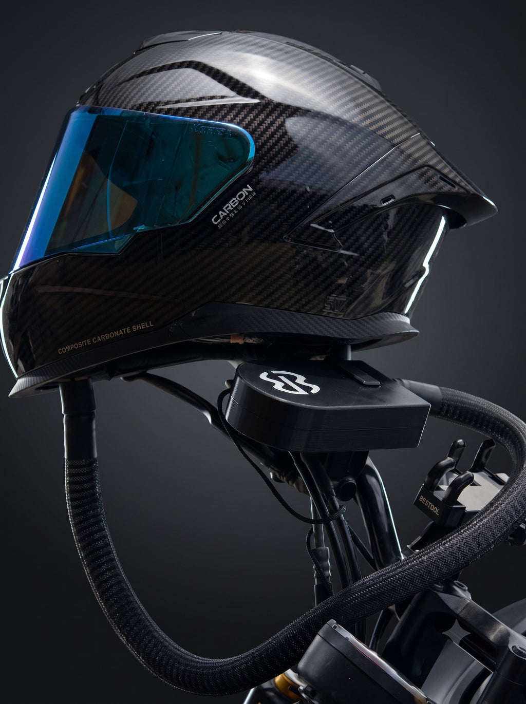 Easi Breezi filter unit mounted on a motorcycle with the braided air hose running up to a carbon full-face helmet